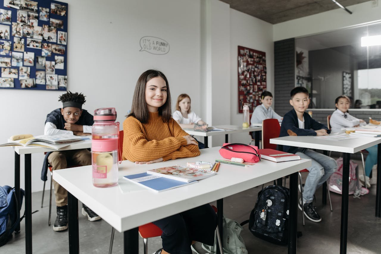 A diverse group of students studying together in a modern classroom setting, engaged in learning and collaboration.